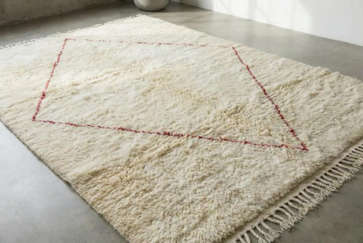 Moroccan wool rug, bold red diamond on a cream high-pile ground in a hallway setting