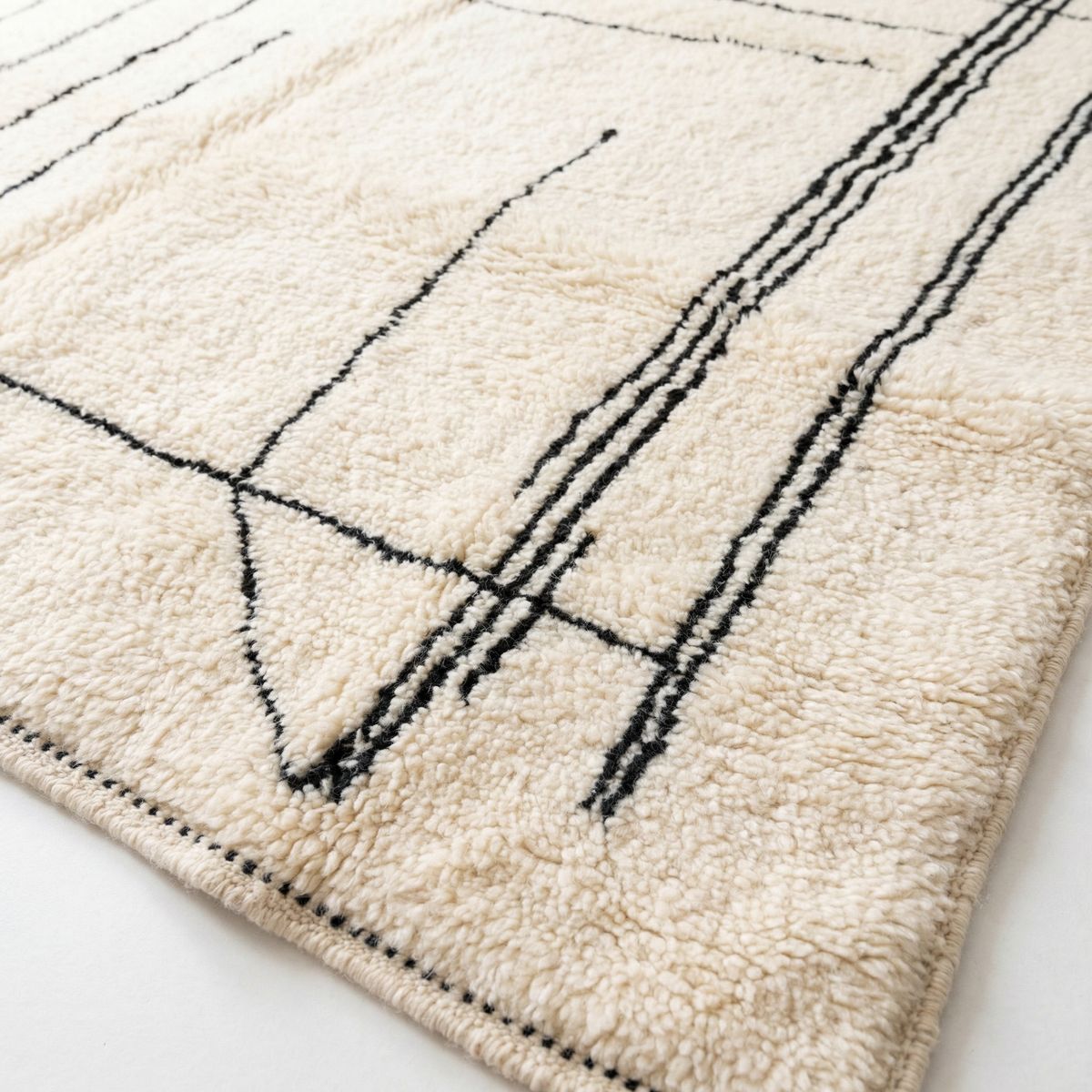 Detail of Beni Ourain wool rug, fine geometric grid on a cream wool ground