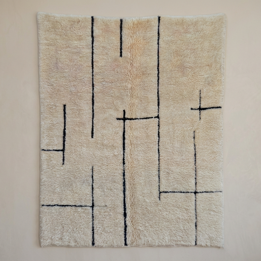 Draufsicht auf den handgeknüpften Beni Ourain Berber-Teppich Maze mit seinem markanten, schwarzen Labyrinth-Linienmuster auf cremefarbenem Grund