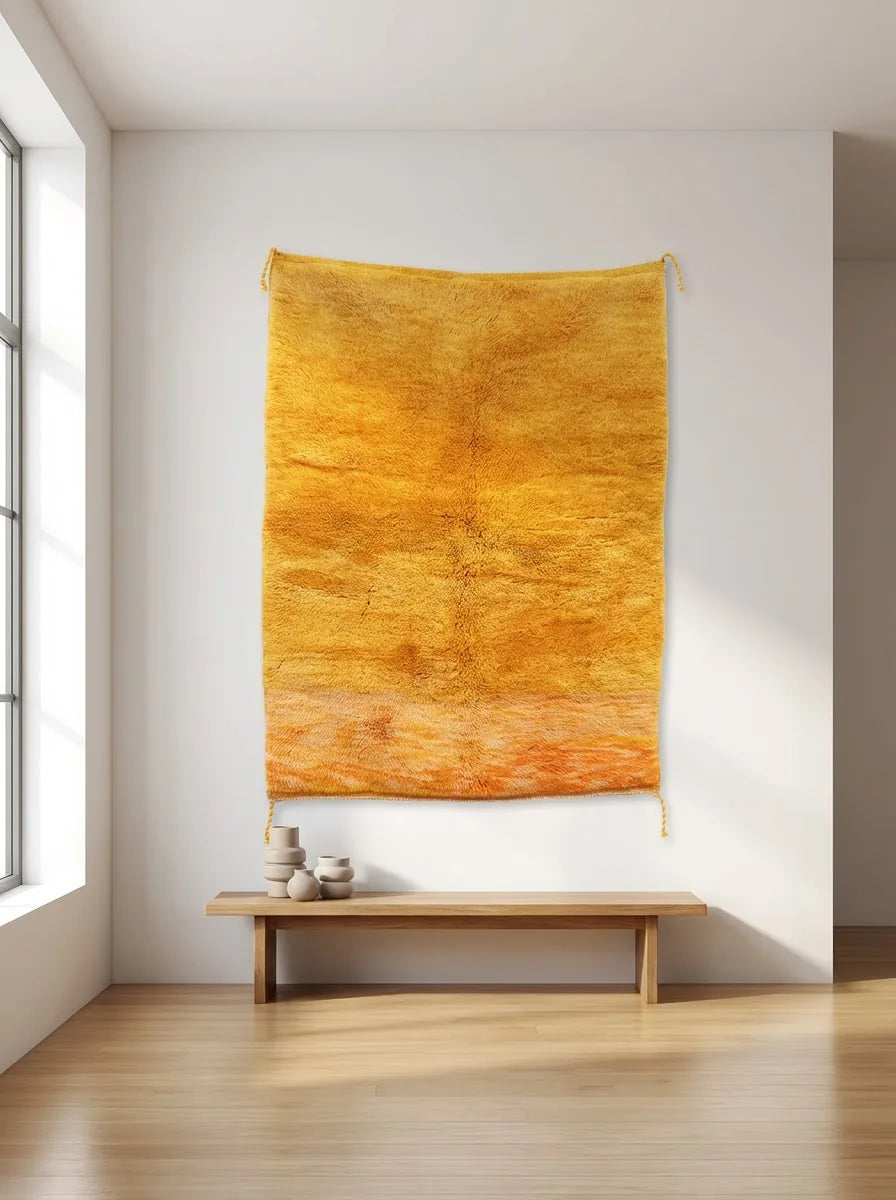 Detail of Moroccan wool rug, rich golden orange ground with a varied color texture