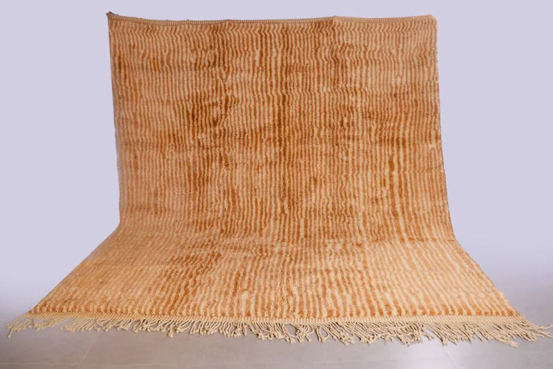 Detail of Moroccan wool rug, warm sand beige ground with a tonal color texture