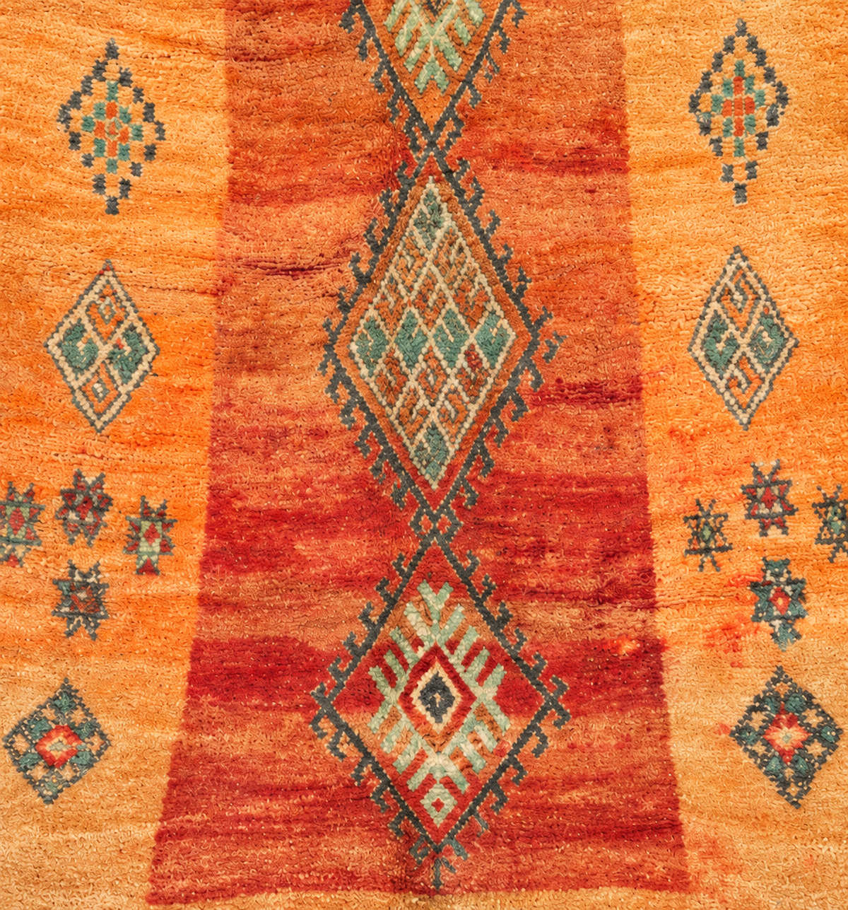 Musterausschnitt des ockerfarbenen Vintage-Teppichs mit grünen Rauten und rostroten Partien, 280 × 185 cm.