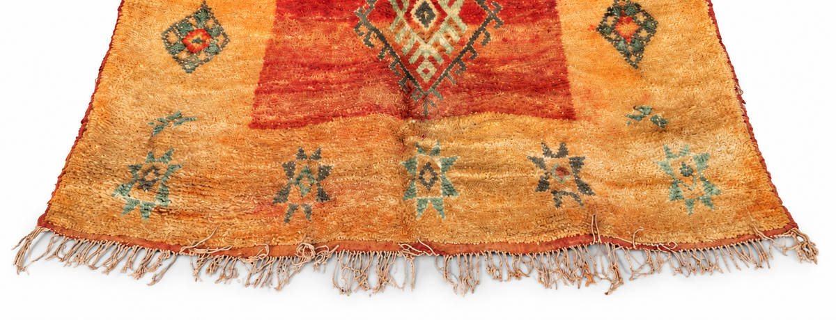 Randausschnitt des ockerfarbenen Vintage-Teppichs mit grünen Rauten und rostroten Partien, 280 × 185 cm.
