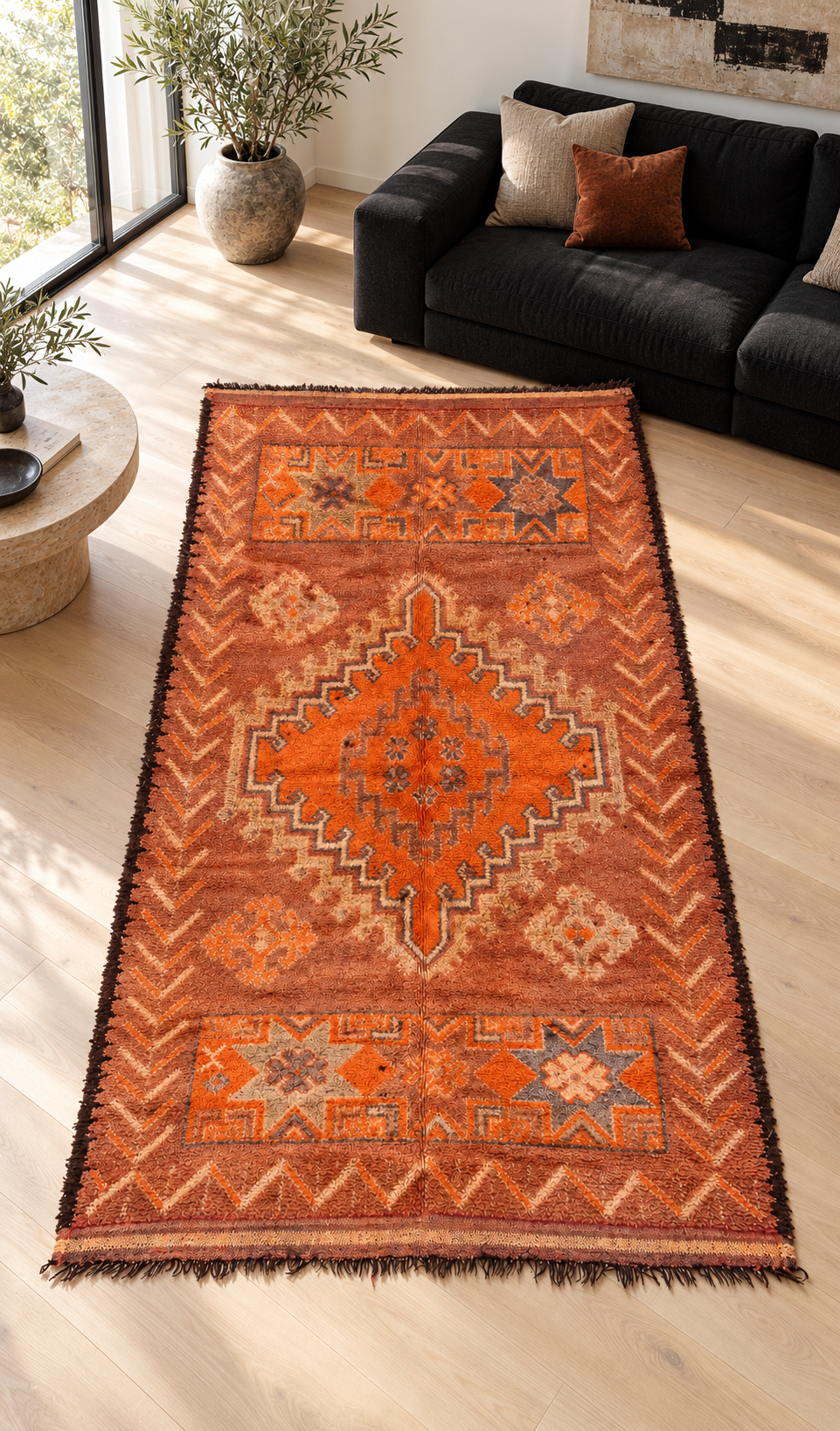 Vintage Teppich Orange mit gezacktem Medaillon, 300 × 176 cm – KI-Rauminspiration mit schwarzem Stoffsofa.